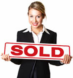 Happy young businesswoman holding sold sign board against white